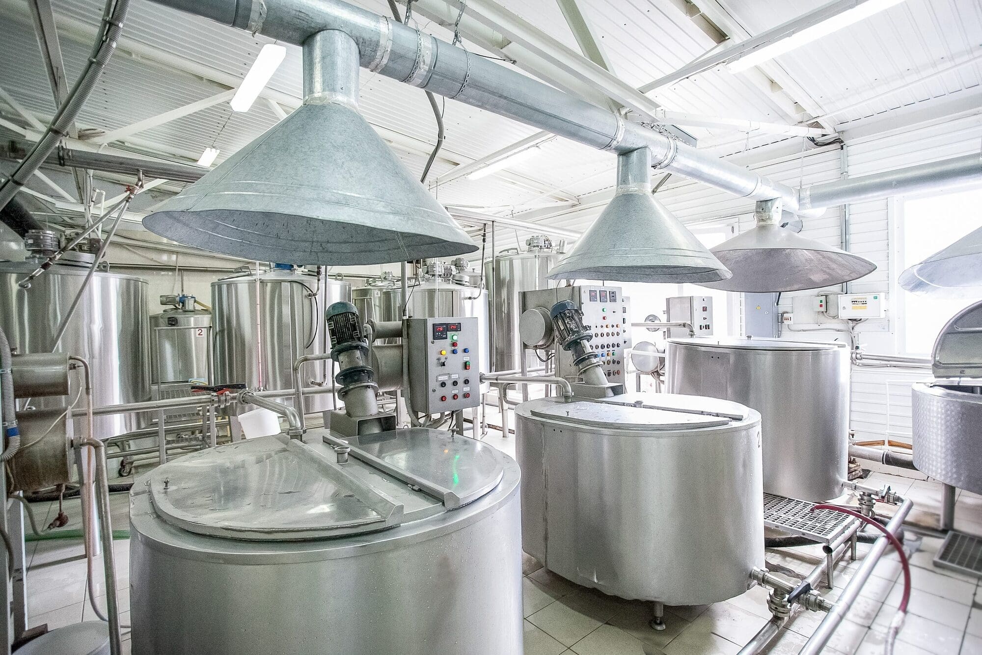 Stainless steel tanks, control panels and extraction hoods in a bright manufacturing plant