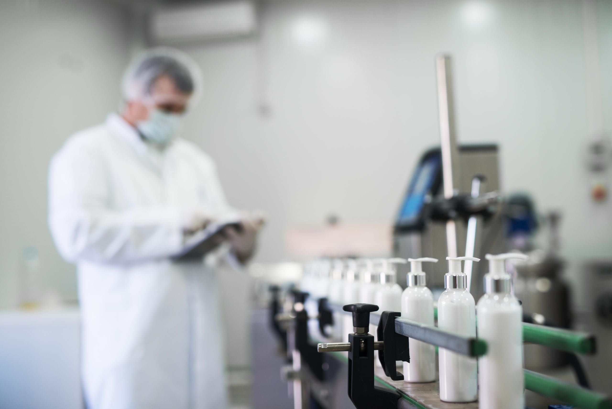 A technician checking bottles on the filling line