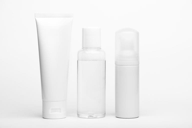 Unbranded white squeeze tube, clear bottle and foam pump bottle on a white background