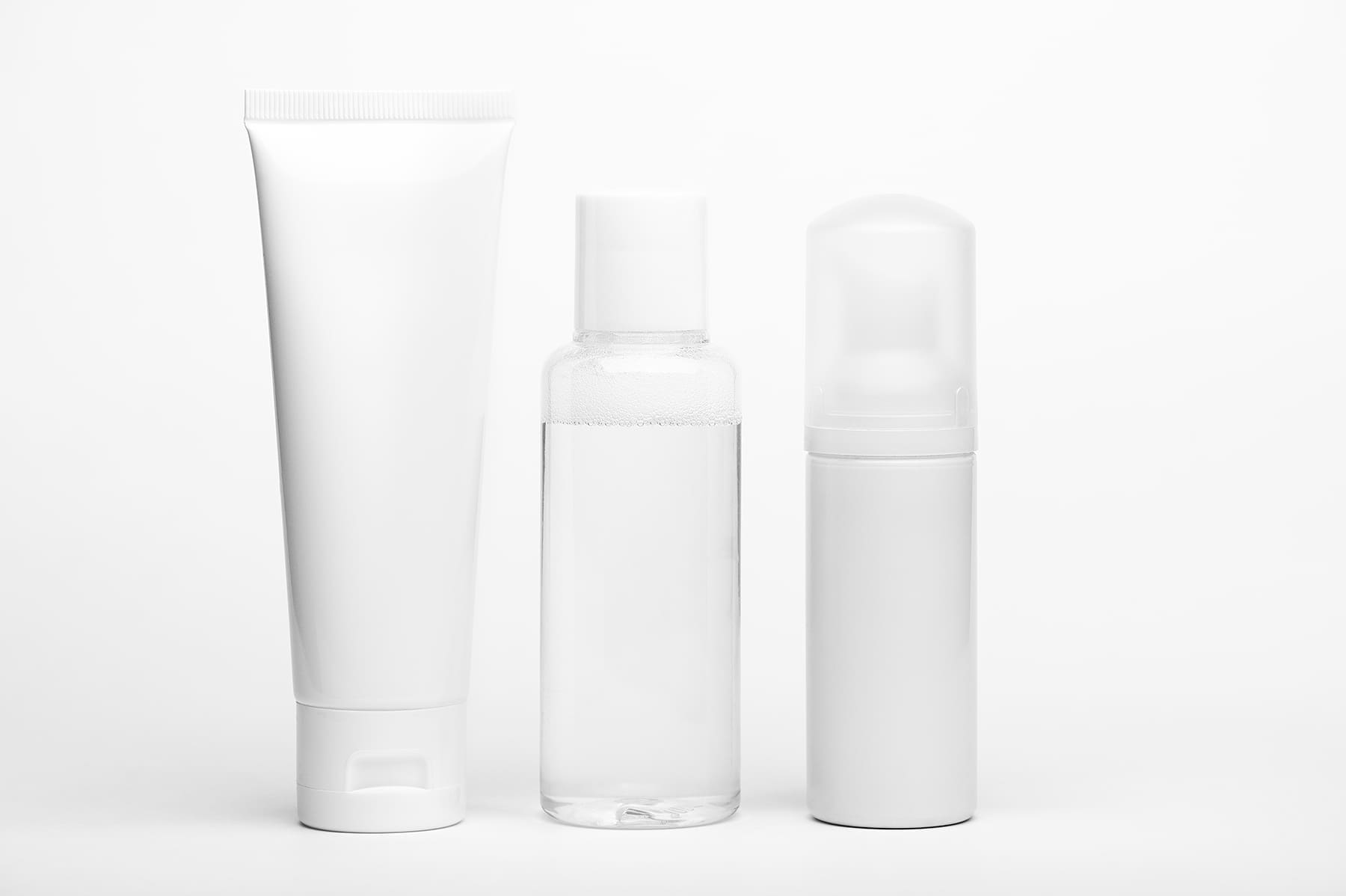 Unbranded white squeeze tube, clear bottle and foam pump bottle on a white background
