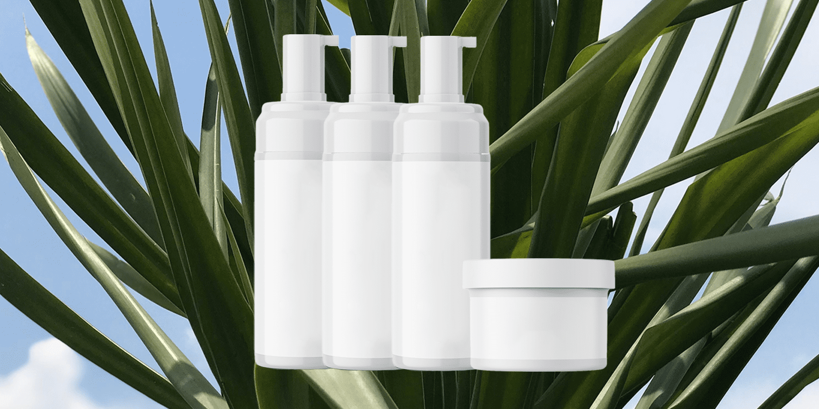 Blank white pump bottles and a jar in front of green palm leaves and blue sky