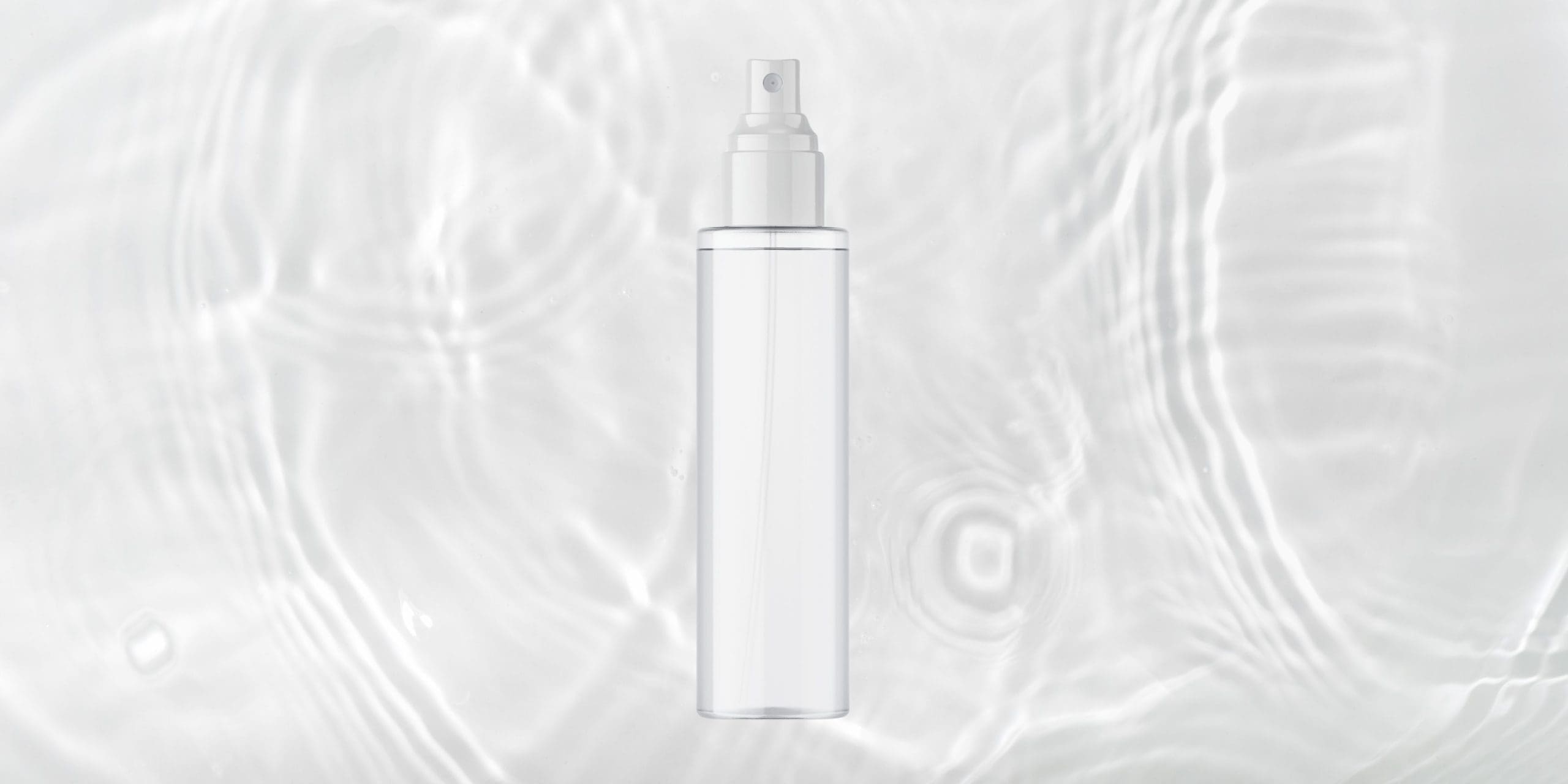 Unlabeled clear mist spray bottle lying on rippling water